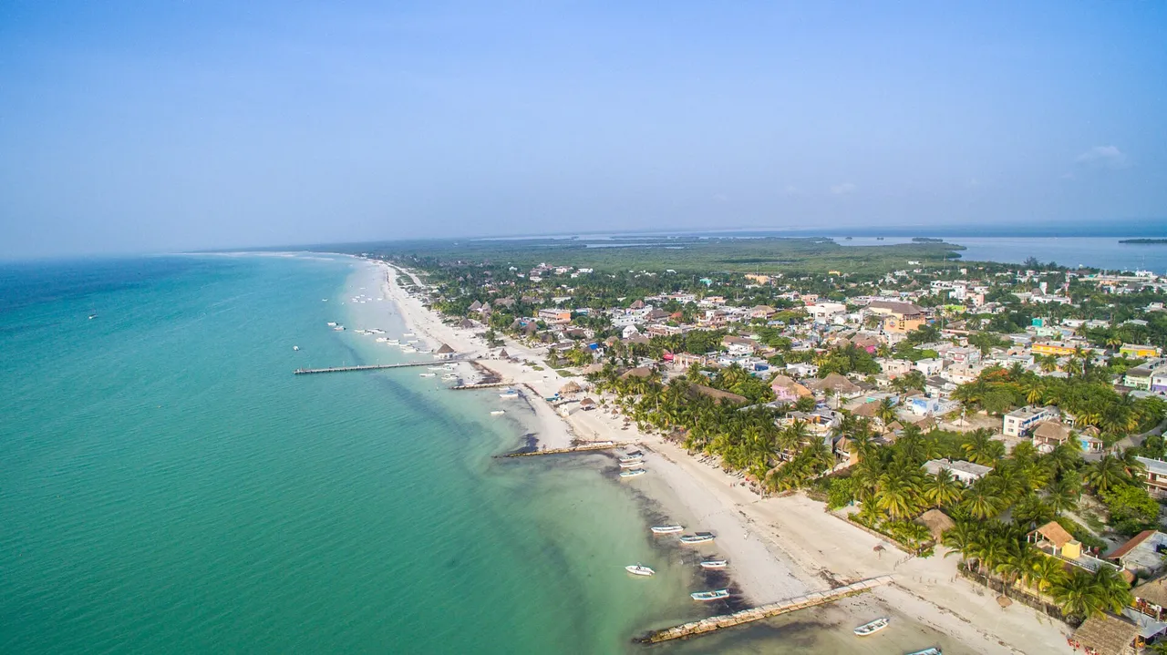 Aerial view of Holbox Island with the town, wooden piers and a long turquoise beach