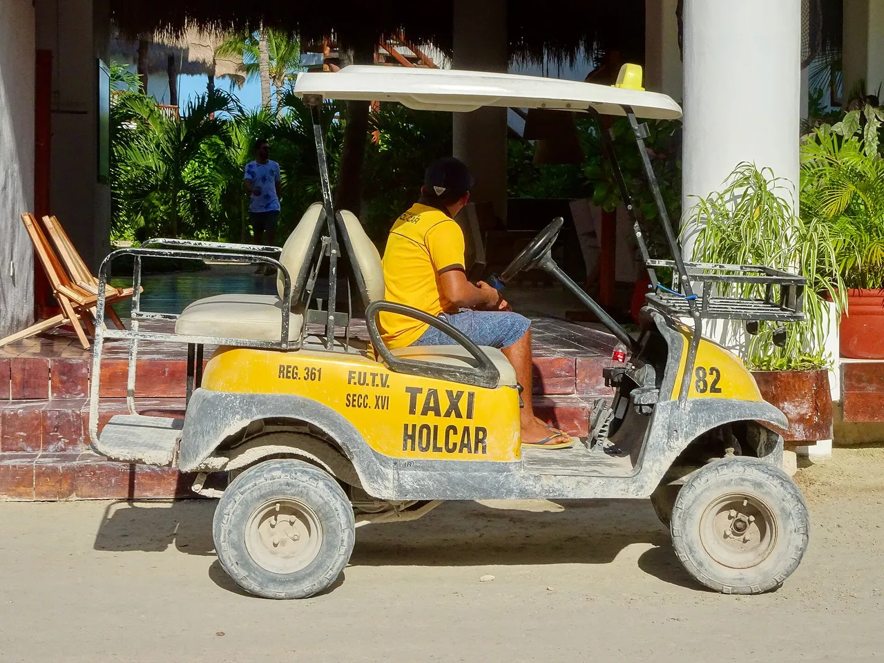 Golf cart working as a taxi on a sandy street in Holbox