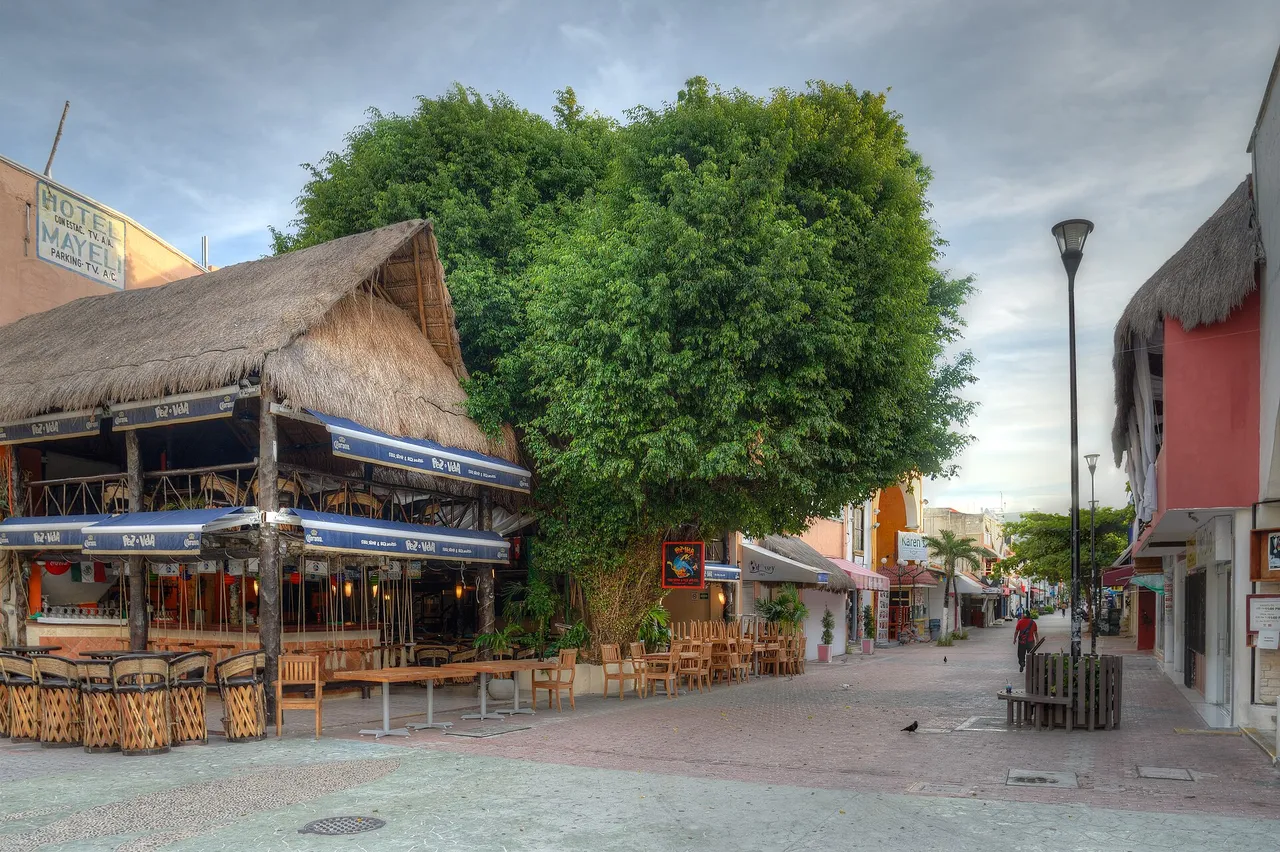 Quinta Avenida in Playa del Carmen almost empty, with a restaurant under a palapa roof