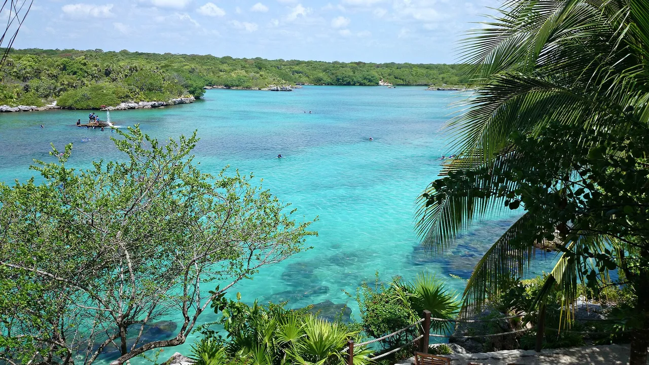 The Xel-Ha inlet seen from above, with turquoise water and a few swimmers in the distance