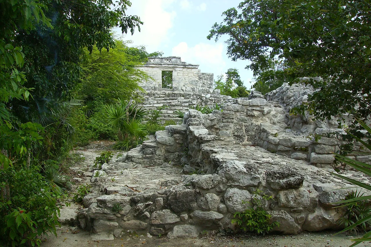 Maya stone structure among vegetation inside Xcaret park
